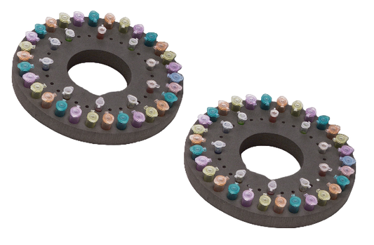 Two circular trays with colorful pastel crayon pieces on a white background